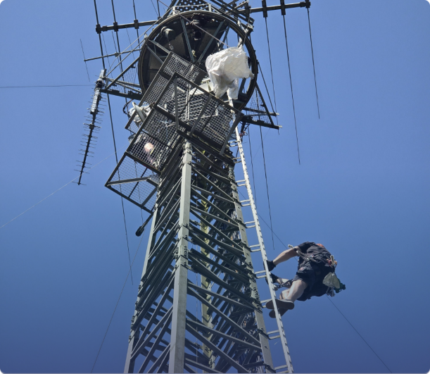 Mitarbeiter klettert auf Richtfunkturm